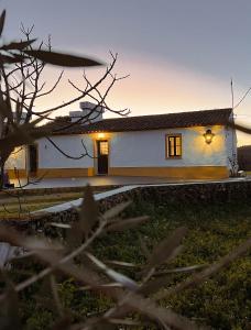a white house with a sunset in the background at Quinta da Utopia in Castelo de Vide