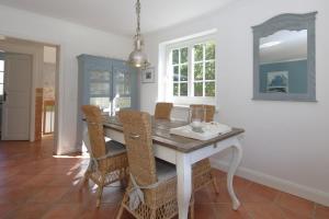 a dining room with a wooden table and chairs at Sylter-Zuhause-Munkmarsch in Munkmarsch