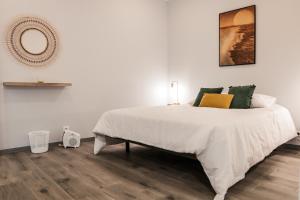 a bedroom with a large white bed and a mirror at Casa Maresia in Fenais da Luz