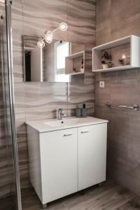 a bathroom with a white sink and a shower at Casa Maresia in Fenais da Luz