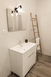 y baño con lavabo blanco y espejo. en Casa Maresia, en Fenais da Luz