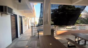 a porch with benches and a table on a building at Seabreeze Beach Lodge in Nasugbu