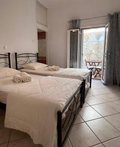 two beds sitting in a room with a window at Aegean Blue House - Spectacular Seaview in Kalámion