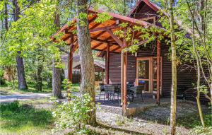 une cabine dans les bois avec une table et des chaises dans l'établissement Cozy Home In Debki With Kitchen, à Dębki