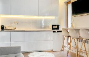 a kitchen with white cabinets and a table and chairs at Stunning Apartment In Stegna With Wifi in Stegna