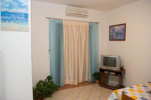 a room with a bed and a television at Apartments Villa Estella in Srima