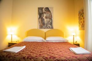 una camera da letto con un grande letto e un dipinto sul muro di Ferdinando II De' Medici a Firenze
