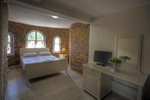 a bedroom with a bed and a desk with a television at Vila Brancoveanu in Eforie Sud