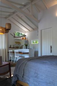 a bedroom with a bed and a table and chairs at Oka Maraú I Charming Bungalows in Marau