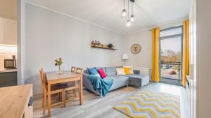 a living room with a blue couch and a table at Apartamenty Sun & Snow Garden Gates in Gdańsk