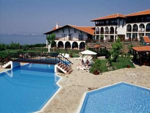 a resort with two swimming pools and a building at Monastery Apartment 14, St. Vlas in Sveti Vlas