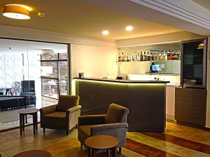 a bar in a restaurant with chairs and a counter at Gran Continental Hotel Taubaté in Taubaté