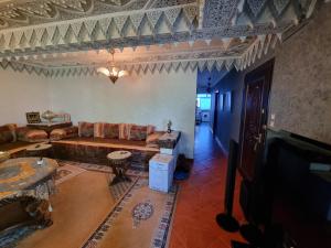 - un salon avec un canapé et une télévision dans l'établissement Appartement Residence Paradise A, à Tanger