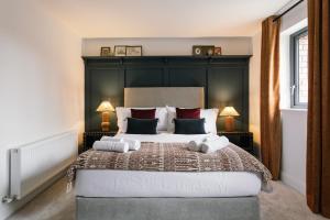 a bedroom with a large bed with a black headboard at The Barn at Corrstown Village in Portrush