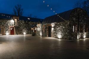 a stone building with lights on it at night at The Barn at Corrstown Village in Portrush