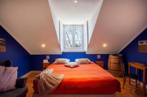 um quarto com uma grande cama laranja e uma janela em Casa do Vinho Sintra Guest House em Sintra