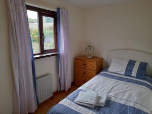 1 dormitorio con cama y ventana en 4 Bedroom Traditional Irish Farm House Killybegs, en Donegal