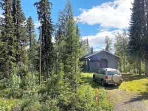 a car parked in front of a cabin in the woods at Holiday home Aurdal in Aurdal