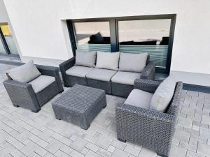 patio con sillas de mimbre, sofá y mesa en Apartment Span, en Fulpmes
