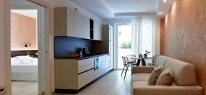 een keuken en een woonkamer met een bank en een bed bij Vilu Suite Centro in Polignano a Mare