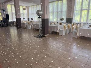 a banquet hall with white tables and white chairs at Pensiunea Oșencuța in Talmesch