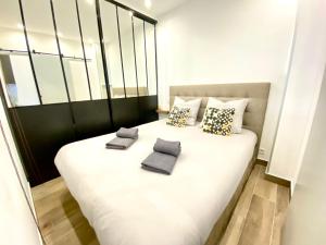 1 cama blanca grande con 2 almohadas en Le Florian By SCLS Locations, en Cannes