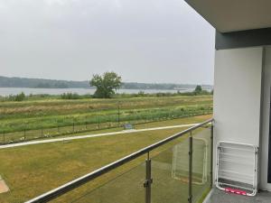 a balcony with a view of a field at Apartament 23 - komfortowy i przestronny. in Zegrze Południowe