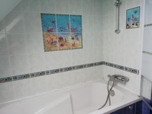 a white bath tub with a faucet in a bathroom at Mon Rêve in Locquémeau