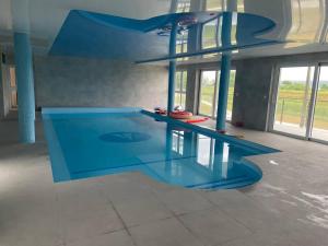 a large swimming pool with a ramp in a room at Apartament 23 - komfortowy i przestronny. in Zegrze Południowe