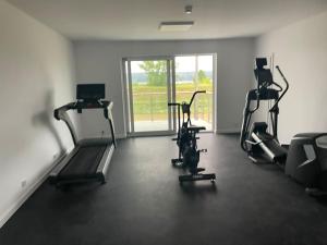 a gym with treadmills and machines in a room at Apartament 23 - komfortowy i przestronny. in Zegrze Południowe