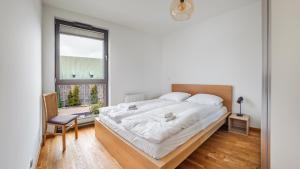 a bedroom with a large bed and a window at Apartamenty Sun & Snow Garden Gates in Gdańsk