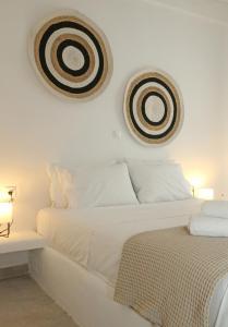 een witte slaapkamer met een bed en twee foto's aan de muur bij Onverra Villa in Rózia