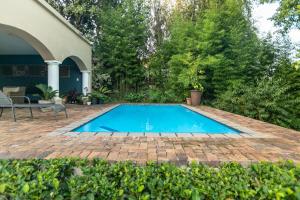 a swimming pool in a yard next to a house at Emmarentia Guest House in Johannesburg