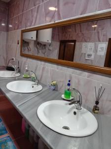 a bathroom counter with two sinks and a mirror at Petra Dorms Hostel in Wadi Musa