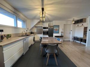 a kitchen with a wooden table and a dining room at Les Pierres de Symphorien - parking gratuit in Vannes