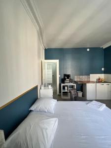 1 dormitorio con cama blanca y pared azul en Key-s Meaux/Suite 5 Saphir/centre/Disney, en Meaux