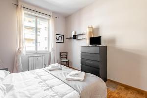 Florence Modern & Bright Apartment! في فلورنسا: غرفة نوم بيضاء بها سرير ونافذة
