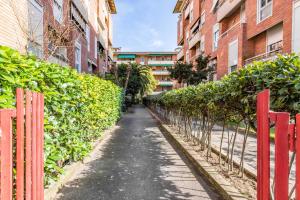 un camino entre dos edificios con una valla roja en Florence Modern & Bright Apartment!, en Florencia