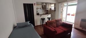 sala de estar con sofá rojo y TV en Acogedor Estudio en Almagro, Buenos Aires en Buenos Aires