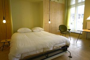 een slaapkamer met een bed, een bureau en een stoel bij LABnul50 Groningen in Groningen