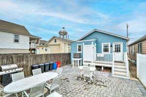 a patio with chairs and a blue house at Beach Retreat with BBQ, Patio and Outdoor Shower! in Seaside Heights