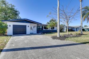 ein Haus mit einer Garage und einer Palme in der Unterkunft Sunny Bradenton Getaway with Poolside Oasis! in Bradenton