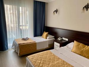 pokój hotelowy z 2 łóżkami i oknem w obiekcie Theluna City Hotel w mieście Antalya