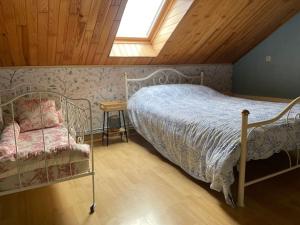 1 dormitorio con 1 cama y 1 silla en el ático en L'Hirondeau de Tenneville, en Tenneville