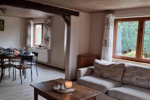 a living room with a couch and a table at L'Hirondeau de Tenneville in Tenneville