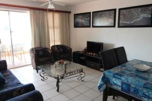 a living room with a couch and a table and a tv at Laguna La Crete 47 in Margate