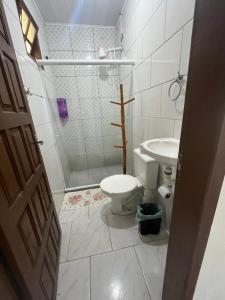 a bathroom with a shower and a toilet and a sink at Pousada Vale Do Aijalom in Cabo Frio +34 photos