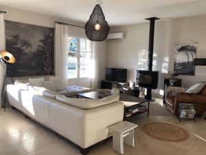 Bastide la Melonnerie في لاكوست: غرفة معيشة مع أريكة بيضاء وتلفزيون