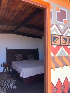 a bedroom with a bed in a room with a wall at Afrikan Krisant Tenerife, Casa Rural Ecologica in Arafo