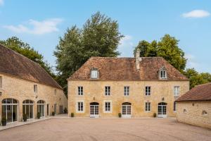 un grand bâtiment en briques avec un toit dans l'établissement Domaine De La Tour, à Saint-Pierre-Canivet